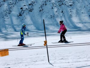 girl taking her first ski lesson with a ski instructor