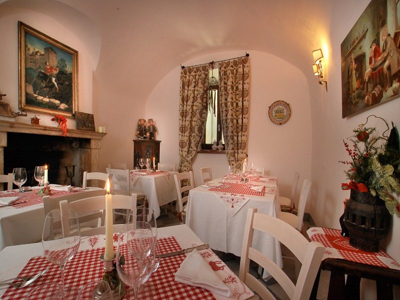 The restaurant with fireplace and tables laid with tablecloths and candles
